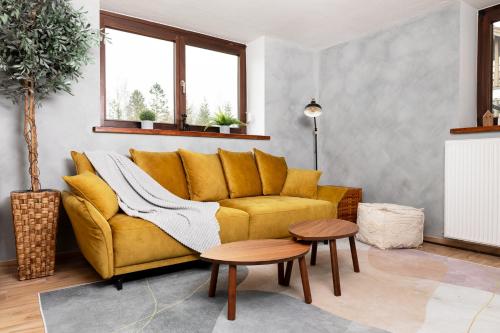ein Wohnzimmer mit einem gelben Sofa und einem Tisch in der Unterkunft Gemütliche Ferienwohnung mit Terrasse und Bergblick in Inzell