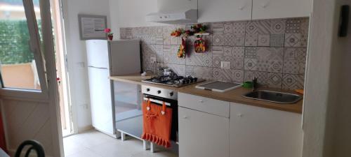 a small kitchen with a stove and a sink at Orange House in Finale
