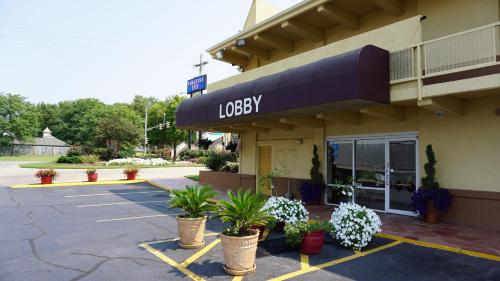 a lobby of a hotel with potted plants in a parking lot at Virginia Inn in Lawrence