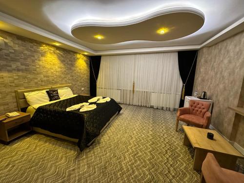 una camera d'albergo con letto e sedia di ÇANKAYA SUIT HOTEL a Ankara