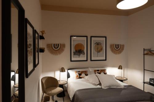 a bedroom with a bed and three pictures on the wall at Palazzo Marzionna in Polignano a Mare