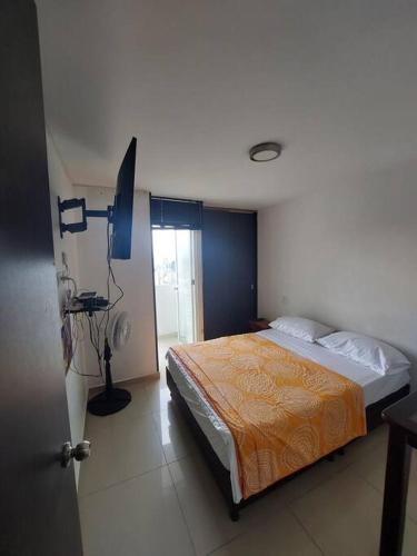 1 dormitorio con 1 cama en una habitación con ventana en Apartaestudio piso 19 con vista panoramica, en Sotomayor