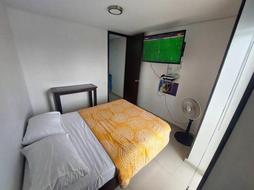 Dormitorio pequeño con cama y TV en Apartaestudio piso 19 con vista panoramica, en Sotomayor