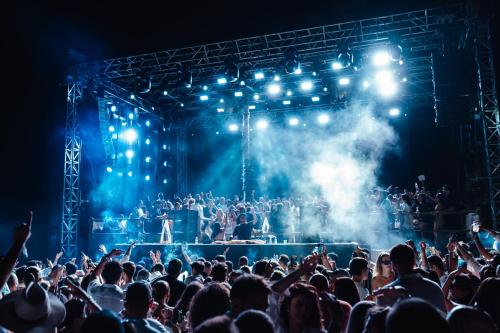 a crowd of people watching a band on a stage at @before sunset in Cesme