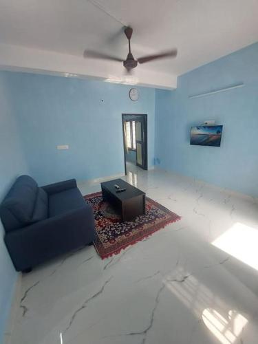 a living room with a couch and a ceiling fan at The Sweet Home in Chennai