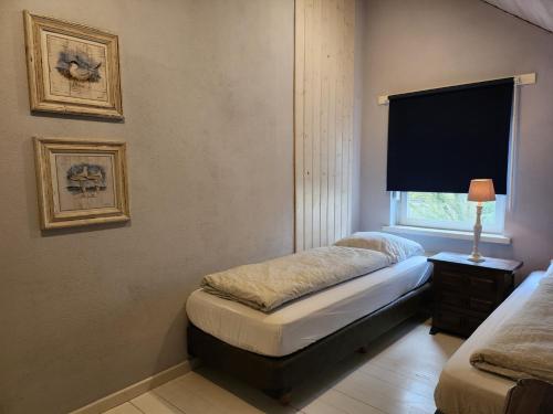 a small bedroom with a bed and a window at Landhuis de heibloem in Heythuysen