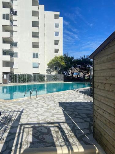 une piscine devant un grand immeuble dans l'établissement Appartement dans une résidence avec piscine à Arcachon, à Arcachon