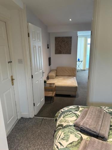 a bedroom with a bed and a living room with a couch at Bestwood Lodge Studio in Nottingham