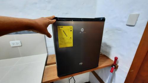 a hand holding a box on top of a counter at Alma de cedrela in Puerto Ayora