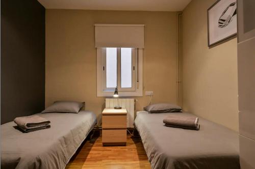 2 camas individuais num quarto com uma janela em Homenfun Barcelona Sants estación em Barcelona