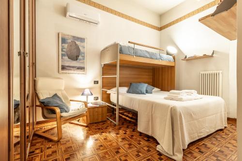 Un dormitorio con una litera y una silla. en Spacious Apt with Kitchenette, Near Piazza Maggiore, en Bolonia