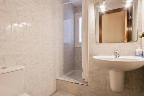 uma casa de banho com um lavatório, um WC e um espelho. em Homenfun Barcelona Sants estación em Barcelona