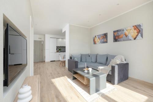 uma sala de estar com um sofá e uma mesa em Villa Tarsis Apartment in Kołobrzeg by Rent like home em Kolobrzeg