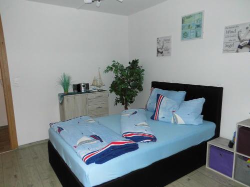 1 dormitorio con 1 cama con sábanas y almohadas azules en Strandzeit Büsum, en Büsum