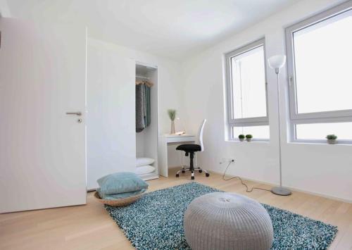 a white living room with a rug and a window at Auszeit Herrsching - 3 Zimmer Wohnung in See Nähe in Herrsching am Ammersee