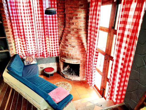 sala de estar con chimenea de ladrillo y sofá en Cabaña Mirador, las Acacias de Teli en Ventaquemada