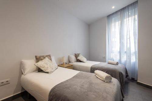 sypialnia z 2 łóżkami i oknem w obiekcie FLORIT FLATS - The Patraix Apartments w Walencji
