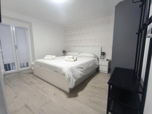 um quarto branco com uma cama branca e uma janela em DioNilo 30 em Nápoles