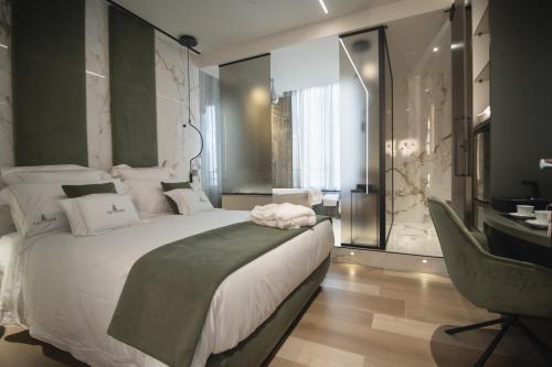 a bedroom with a large white bed and a desk at Tritone Luxury Suites Fontana di Trevi in Rome