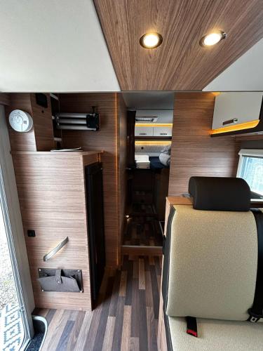 Ein Wohnmobil mit einem Bett und Holzwänden in der Unterkunft London Explorers' Pod, Vaaroom in Romford