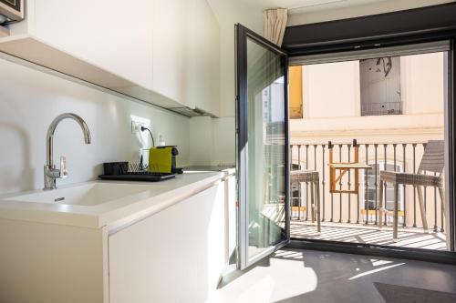 a kitchen with a sink and a balcony at Apartamentos 7 dreams in Málaga
