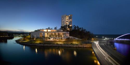 a large building next to a river at night at SEAMARQ HOTEL in Gangneung