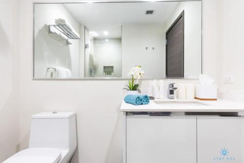 ein weißes Badezimmer mit einem Waschbecken und einem Spiegel in der Unterkunft Tropical Oasis - Rooftop Pool- Near Beach - Gym in Hollywood