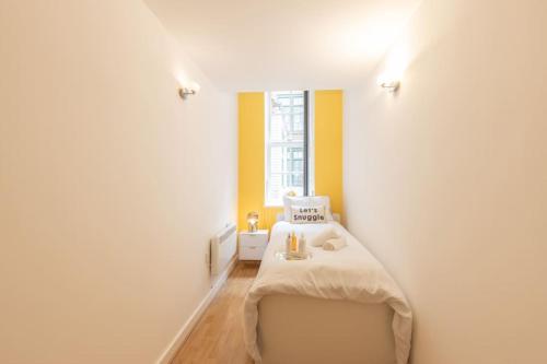 ein Schlafzimmer mit einem Bett in einem Zimmer mit einem Fenster in der Unterkunft Cosy, Modern City Centre Apartment Free Parking in Leicester