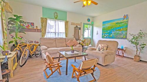 a living room with a couch and a table and chairs at beach house Cg7p in Okinawa City