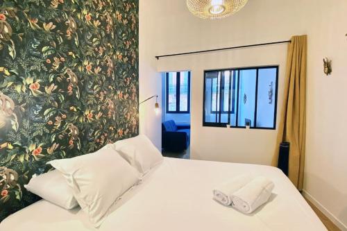 une chambre avec un lit avec un mur de fleurs dans l'établissement Le T2 Capitole - Hypercentre - Metro - Wifi, à Toulouse