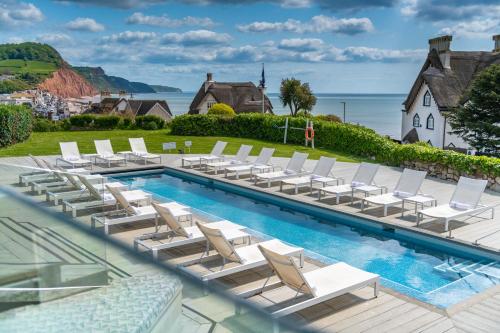 錫德茅斯的住宿－Harbour Hotel & Spa Sidmouth，一个带躺椅的游泳池和一个游泳池