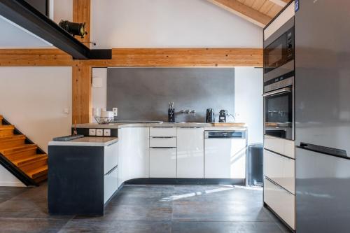 une cuisine avec des appareils blancs et un escalier dans l'établissement Spacious Duplex in the Heart of Cannes, à Cannes