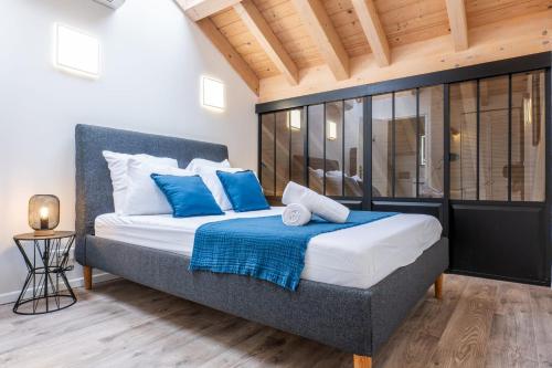 une chambre avec un lit avec des oreillers bleus et blancs dans l'établissement Spacious Duplex in the Heart of Cannes, à Cannes