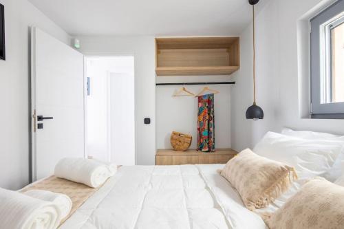 a bedroom with a large white bed and a window at Kea 360 VILLAS- Dionysos Den in Korissia