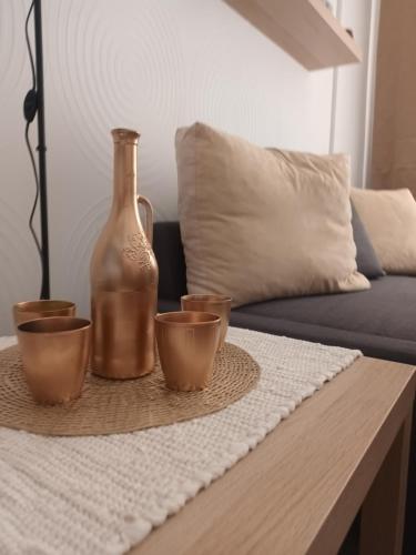a table with a bottle and three cups on it at STUDIO DELUXE IN MARINA CAPE 4 stars complex 33 7 in Aheloy