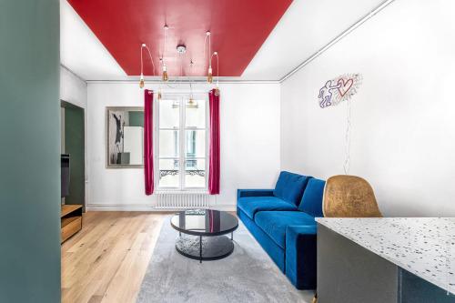 un salon avec un canapé bleu et une table dans l'établissement Gros Caillou - Monttessuy 1bdr by B'Your Home, à Paris