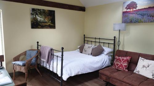 sypialnia z łóżkiem i kanapą w obiekcie Charming Country Retreat w mieście Lincoln