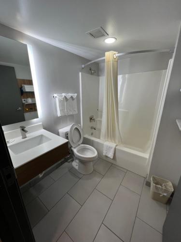 a bathroom with a tub and a toilet and a sink at Microtel Inn & Suites by Wyndham Charlotte/Northlake in Charlotte