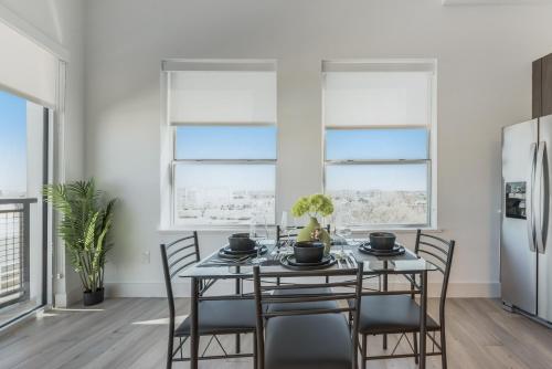 a dining room with a table and chairs and two windows at Contemporary 2BR I Gym I Parking I Workspace in Dallas