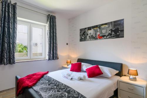 a bedroom with a bed with red and white pillows at Villa Mihaela with private pool, jacuzzi and free secure parking in Trogir