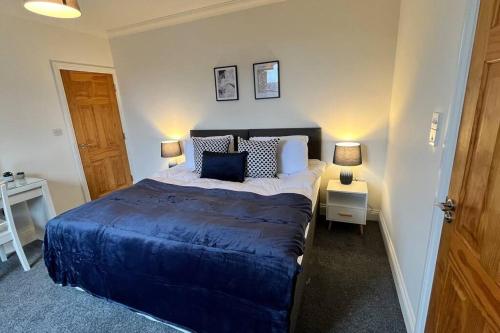 a bedroom with a bed with blue sheets and two lamps at Large apt, sleeps 4, in picturesque Wimborne town - The Westborough Nook in Wimborne Minster