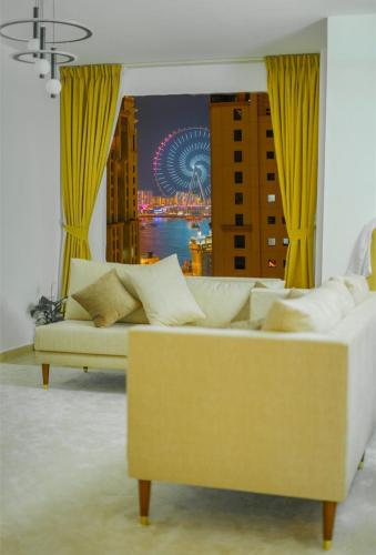 a white couch in a room with a view of a city at Curve Hostel JBR in Dubai