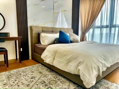a bedroom with a bed with blue pillows and a window at 2R2B GAIA RESIDENCE Gamuda Garden Rawang SkylineLuge in Rawang