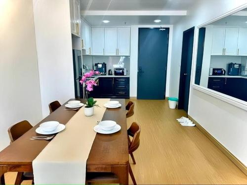 a dining room with a long table and a kitchen at GAIA RESIDENCE Gamuda Garden Rawang Skyline Luge in Rawang