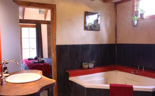 baño con bañera grande y lavamanos en La Boheme Secluded Luxury Spa Villa, en Daylesford