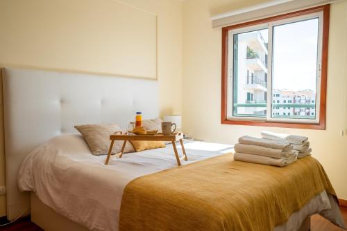a bedroom with a bed with a table on it at Forum Madeira Ajuda Apartment in Funchal