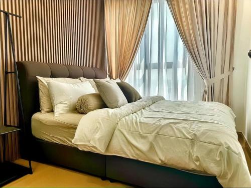 a bed with white sheets and pillows next to a window at GAIA RESIDENCE Gamuda Garden Rawang Skyline Luge in Rawang