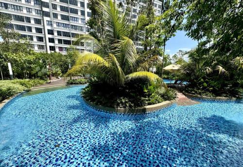 a large blue pool with palm trees and buildings at GAIA RESIDENCE Gamuda Garden Rawang Skyline Luge in Rawang