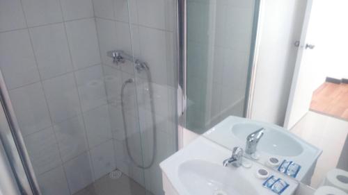 un baño con ducha y lavabo en Hostal del Rio, en Concepción