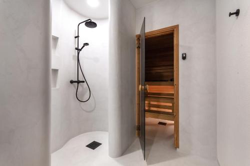 a bathroom with a shower and a wooden door at Luxury Villa with 6 Bedrooms & Pool etc in Tallinn